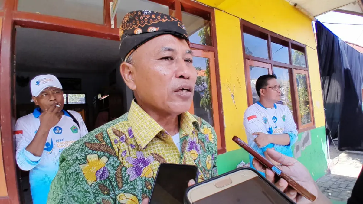 MENJAWAB: Kepala Dispendikbud Pamekasan Ahmad Basri Yulianto saat wawancara cegat dengan wartawan.