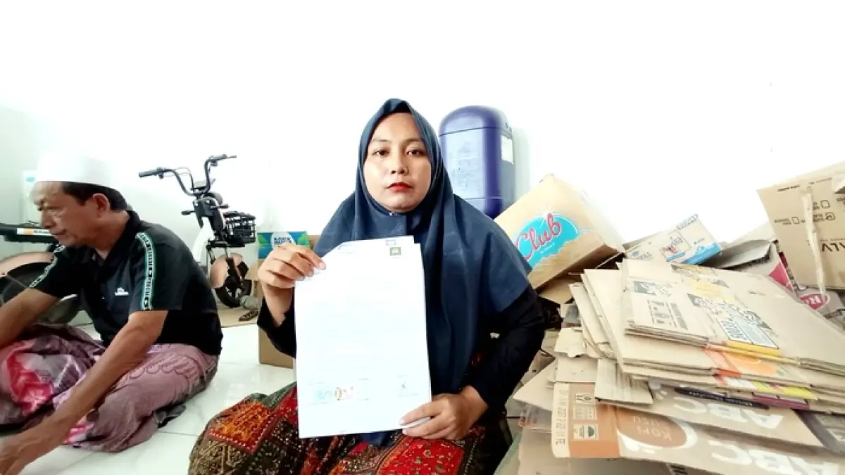 TEMPUH JALUR HUKUM: Komariyah menunjukkan bukti-bukti kasus dugaan penipuan pembelian tanah kaveling di rumahnya, Senin (6/7). (ZEINAL ABIDIN/JPRM)