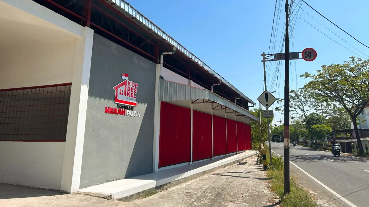 BELUM BEROPERASI: Warga melintas di sekitar KDKMP Kelurahan Polagan, Sampang, Senin (6/7). (UBAIDILLAHIR RA’IE/JPRM)