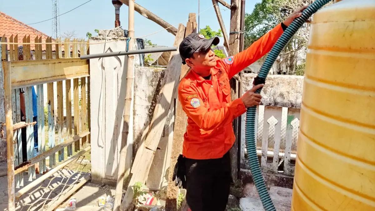 TERDAMPAK KEKERINGAN: Petugas BPBD Bangkalan saat mendistribusikan air bersih di Desa Pangeleyan, Kecamatan Tanah Merah, Jumat (3/7). (BPBD BANGKALAN UNTUK JPRM)