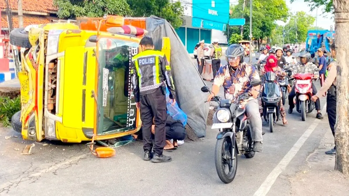 LAKA TUNGGAL: Petugas mengevakuasi truk terguling di Jalan KH Wahid Hasyim, Sampang, Rabu (8/7). (AYU LATIFAH/JPRM)