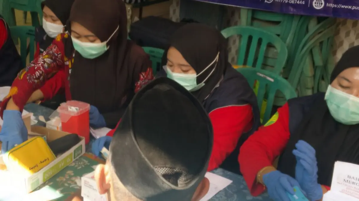 MELAYANI: Petugas saat melayani cek kesehatan gratis di Desa Jenangger, Kecamatan Batang-Batang, Sumenep, Kamis (2/7).