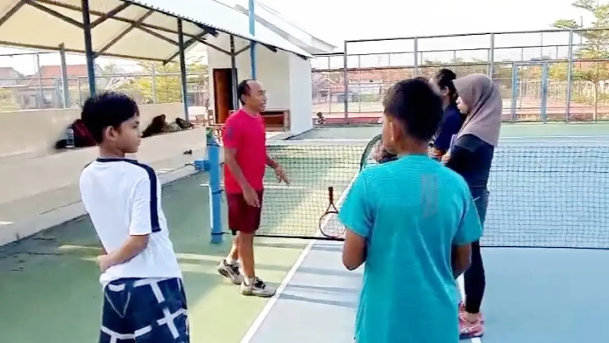 PENUH SEMANGAT: Pengurus Bidang Pembinaan Prestasi Pelti Sampang Mas’udi saat melatih atlet binaannya di lapangan tenis Sampang Sport Center (SSC), beberapa waktu lalu. (PELTI UNTUK JPRM)