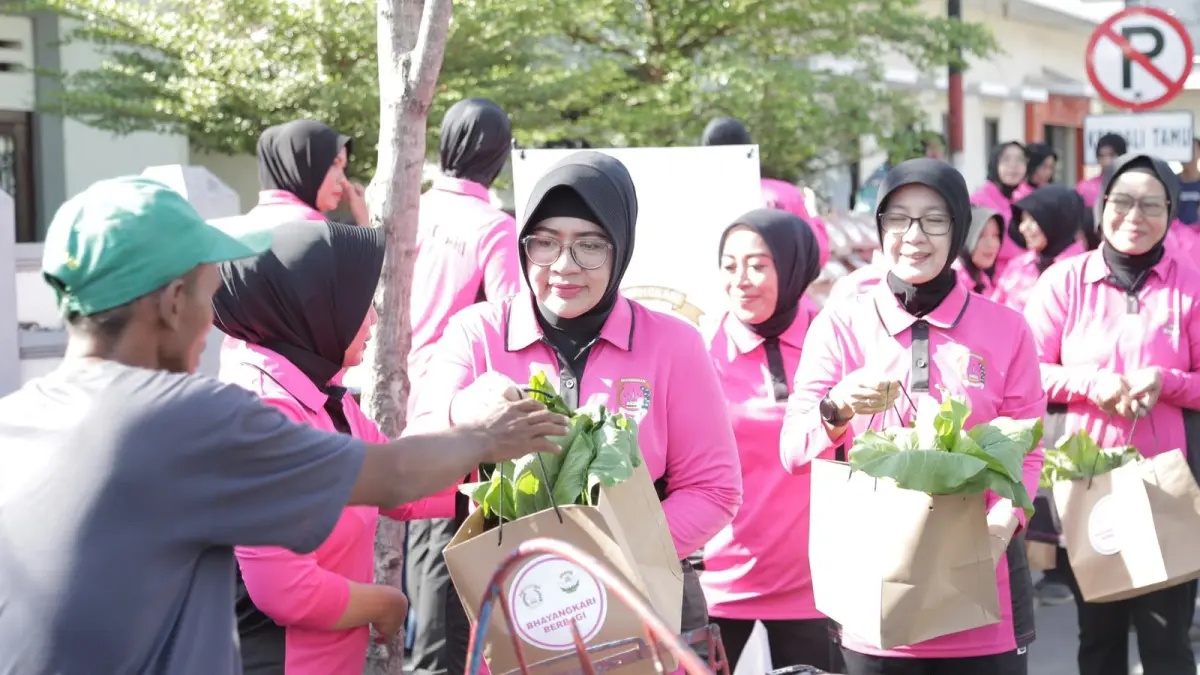 BERBAGI: Ketua Cabang Bhayangkari Sampang Daru Hartono saat membagikan hasil panen P2L kepada warga di Jalan Trunojoyo, Sampang, Jumat (10/7). (HUMAS POLRES UNTUK JPRM)