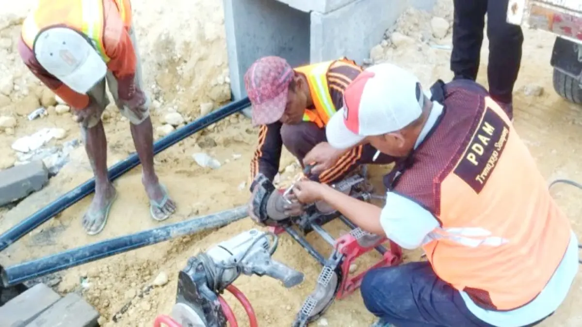 JARINGAN BARU: Petugas Perumdam Trunojoyo saat memasang pipa air di area gedung SRT, Kamis (9/7). (PT WASKITA UNTUK JPRM)