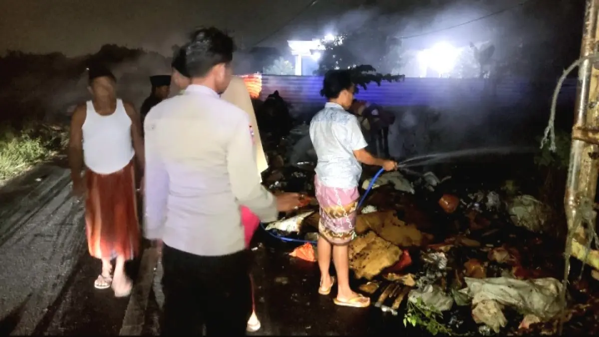KECELAKAAN: Petugas dan warga Desa Arok, Kecamatan Burneh, Bangkalan, berusaha memadamkan pikap yang terbakar, Sabtu (11/7). (SATPOL PP UNTUK JPRM)