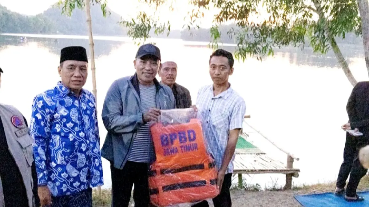 SIAP DIKEMBANGKAN: Bupati Sampang Slamet Junaidi memberikan bantuan alat pelampung pada warga yang mengelola wisata Waduk Klampis, di Desa Kramat, Kecamatan Kedungdung, Minggu (12/7). (KOMINFO UNTUK JPRM)