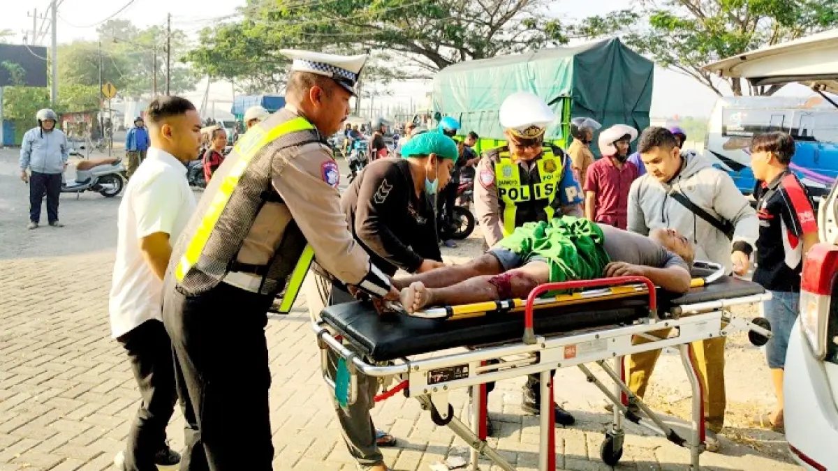 TERLIBAT LAKA: Petugas Satlantas Polres Bangkalan mengevakuasi korban kecelakaan di Jalan Raya Tangkel, Kecamatan Burneh, Senin (13/7). (POLRES BANGKALAN UNTUK JPRM)