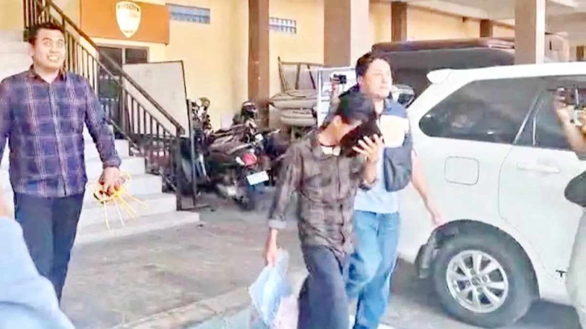 DIKAWAL KETAT: Tersangka rudapaksa digiring anggota Polres Sampang saat hendak dilimpahkan pada Kejari Sampang, Selasa (14/7). (UBAIDILLAHIR RA’IE/JPRM)