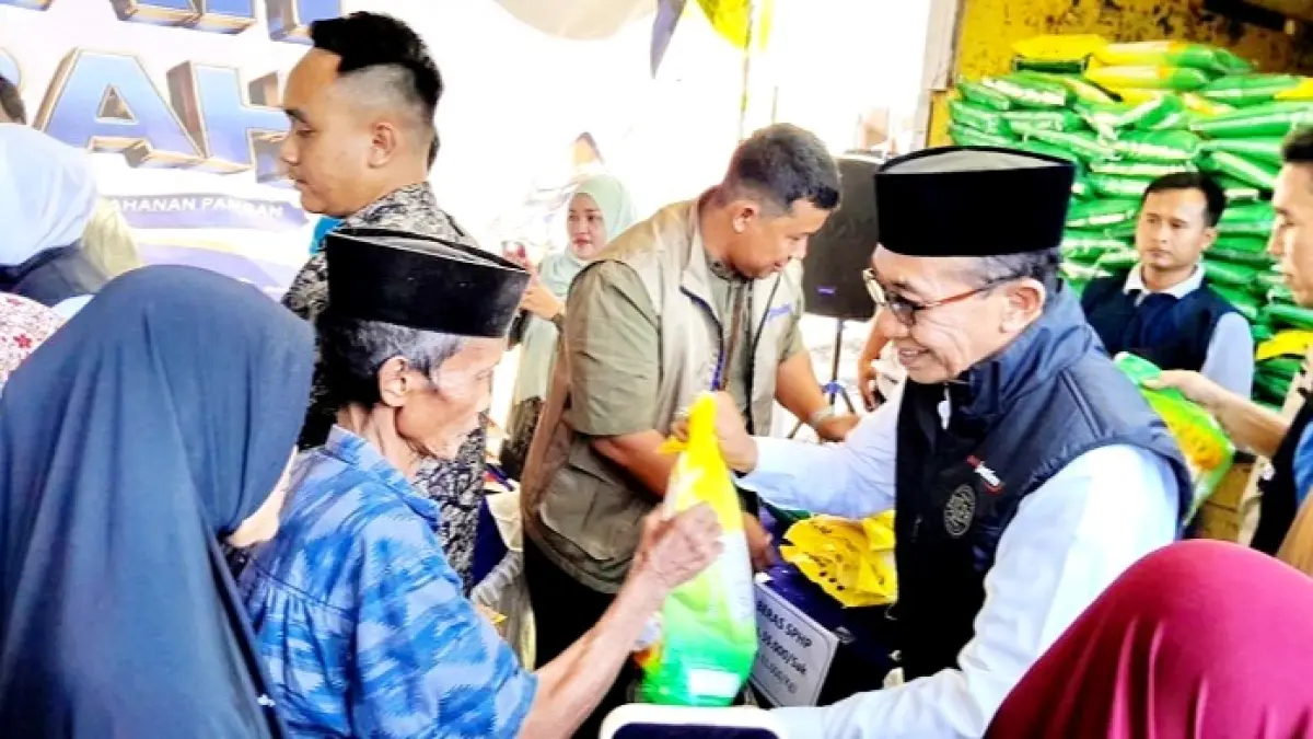 ANTUSIAS: Bupati Pamekasan KH. Kholilurrahman memberikan paket pembelian beras kepada masyarakat di pasar murah di Kecamatan Larangan Minggu (19/7). (M. KHOLIL RAMLI/JPRM)