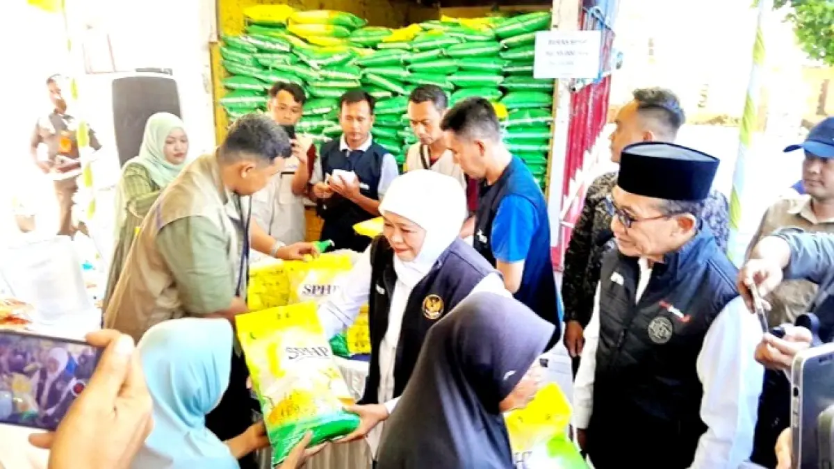 SEMANGAT: Bupati Pamekasan KH. Kholilurrahman mendampingi Gubernur Jawa Timur Khofifah Indar Parawansa saat memberikan paket beras kepada masyarakat di pasar murah di Kecamatan Larangan, Minggu (19/7). (M. KHOLIL RAMLI/JPRM)
