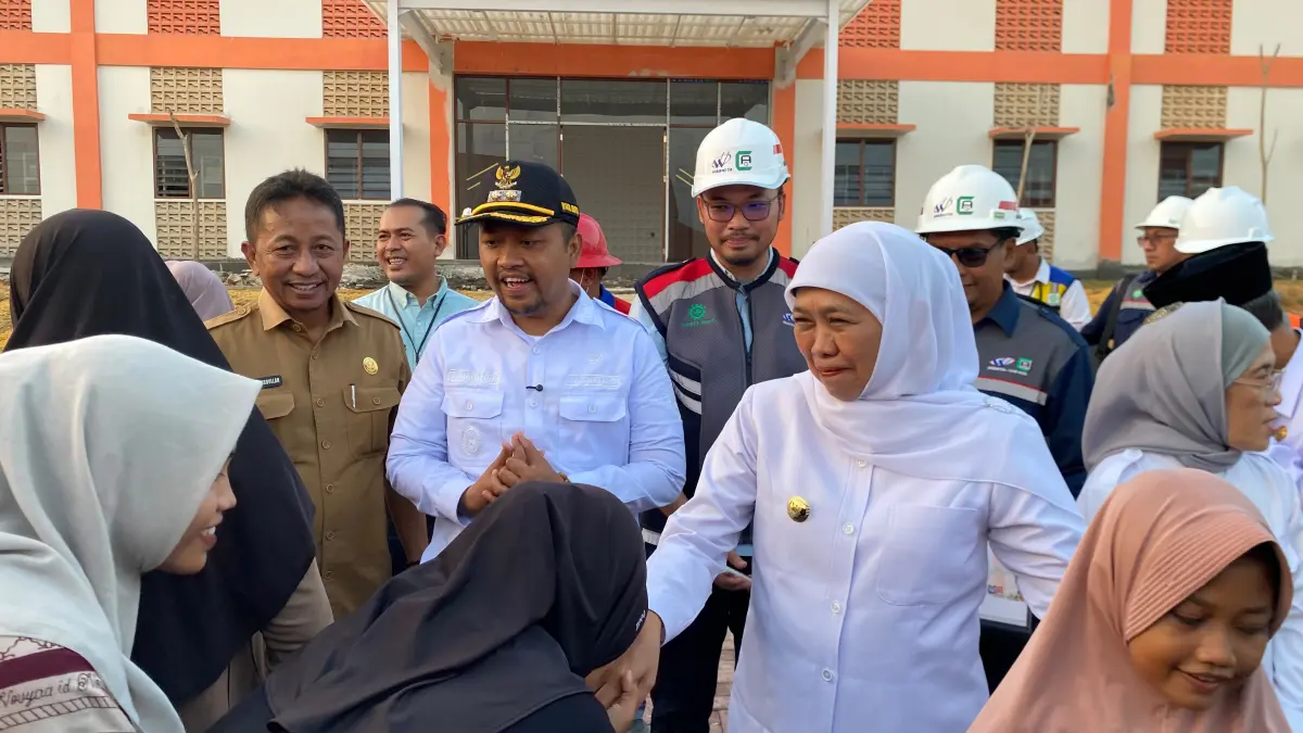 BERSINERGI: Wabup Sampang Ahmad Mahfudz (kiri) saat mendampingi Gubenur Jawa Timur Khofifah Indar Parawansa menyerahkan santunan kepada calon siswa saat meninjau pembangunan SRT 1 Sampang, Selasa (21/7). (AYU LATIFAH/JPRM)