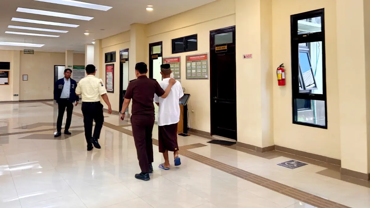 DIGIRING: Terdakwa AR digiring petugas tahanan kejari untuk mengikuti dakwaan di Pengadilan Negeri Sampang Senin (20/7). (UBAIDILLAHIR RA’IE/JPRM)