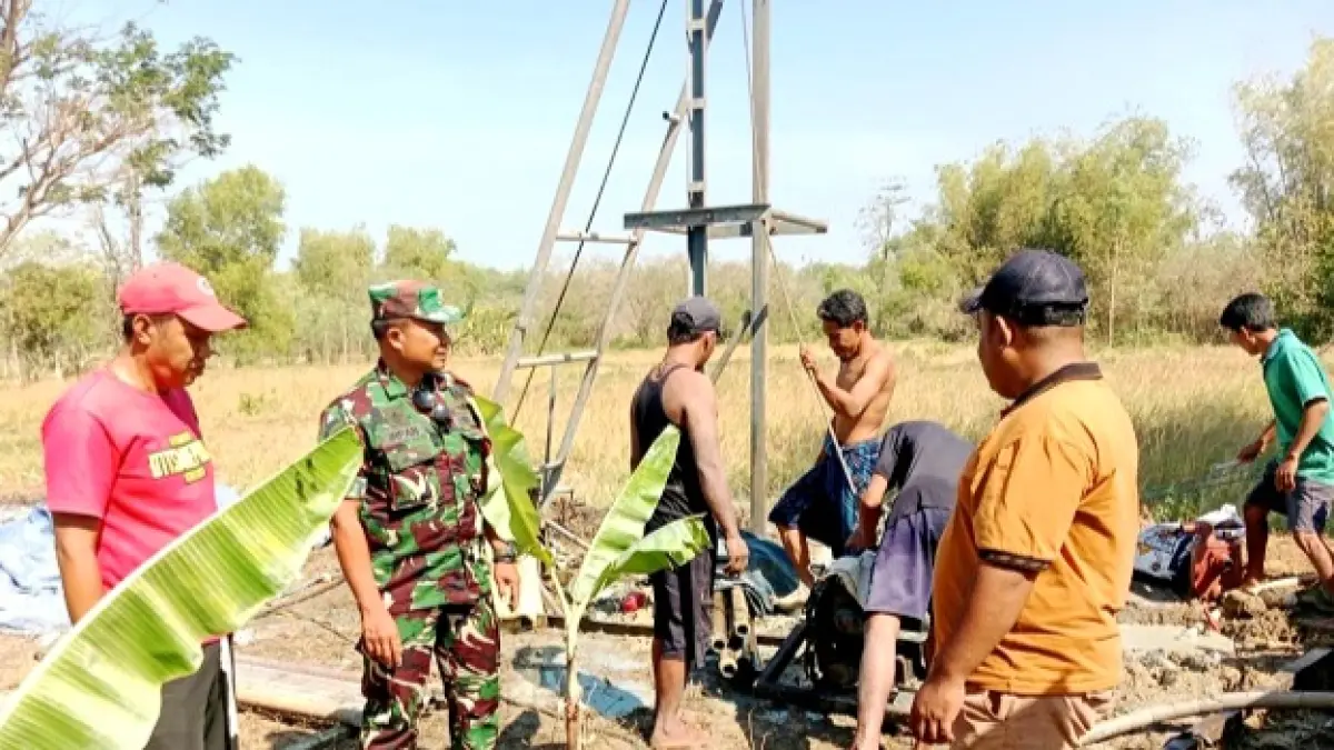 DIDUGA MENGELUARKAN GAS: Anggota TNI dan warga mengecek langsung sumur bor yang diduga mengeluarkan gas di Desa Serabi Timur, Kecamatan Modung, Bangkalan, Selasa (21/7). (POLRES BANGKALAN UNTUK JPRM)