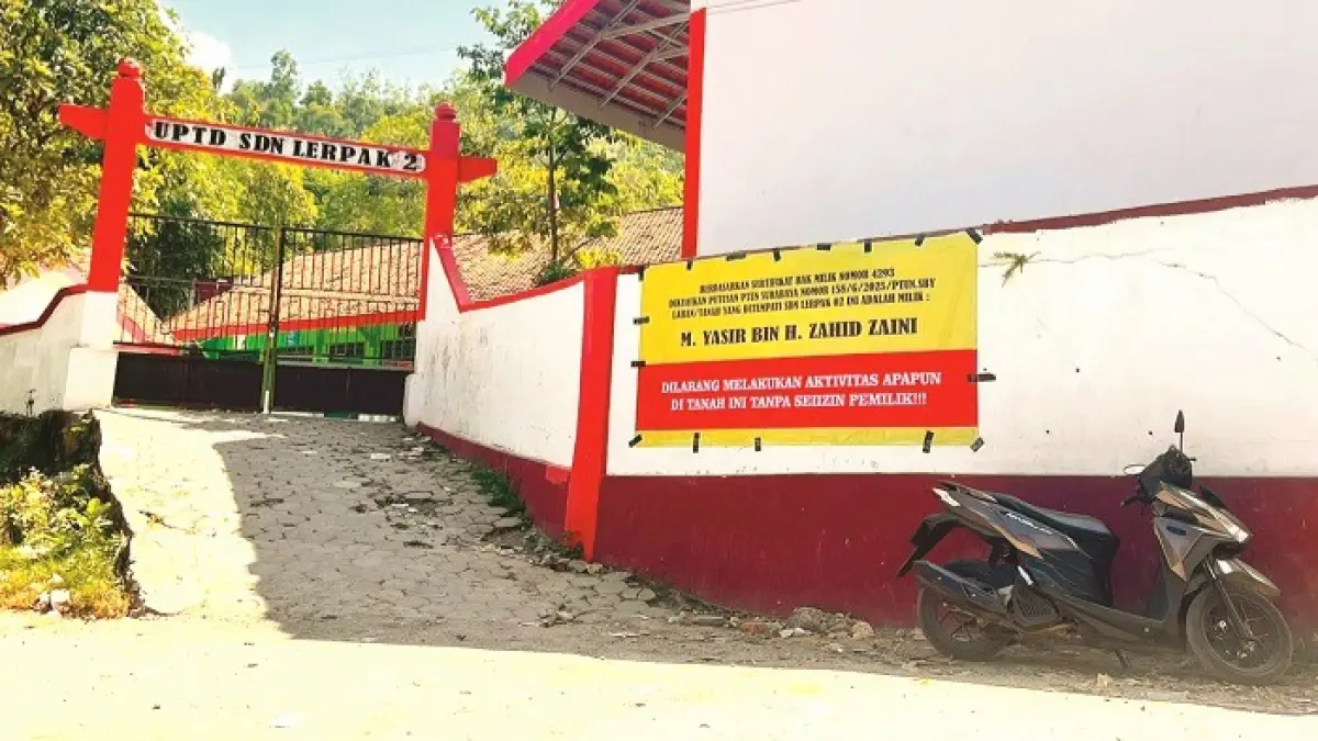 DITUTUP: Spanduk larangan beraktivitas terpasang di pintu gerbang SDN Lerpak 2 Kecamatan Geger, Bangkalan, Rabu (22/7). (ABDURRAHMAN UNTUK JPRM)