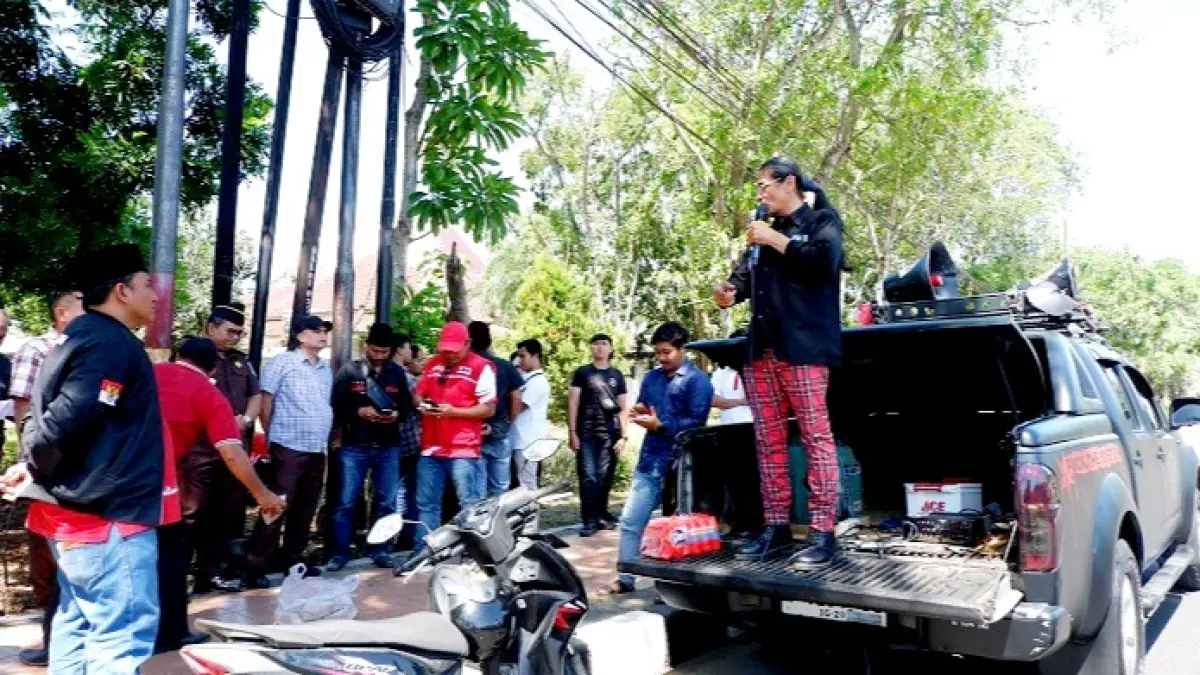 MENGGELEGAR: Aktivis Bangkalan Risang Bima Wijaya tengah orasi di depan kantor Kejaksaan Negeri Bangkalan Rabu (22/7). (VIVIN AGUSTIN HARTONO/JPRM)