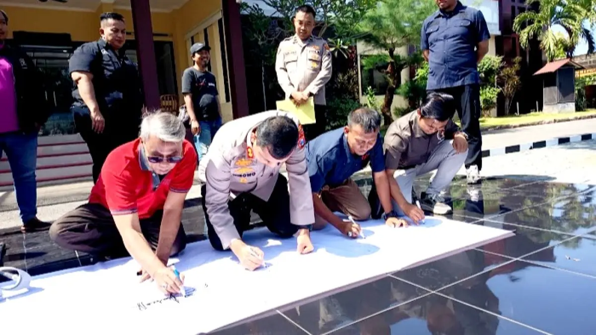 KOMITMEN: Kapolres Bangkalan AKBP Wibowo menandatangani surat pernyataan di Mapolres Bangkalan, Kamis (23/7). (ZEINAL ABIDIN/JPRM)