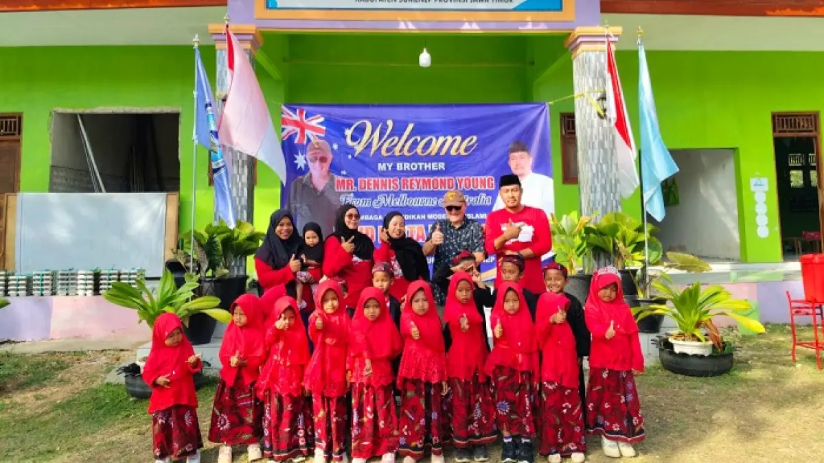 PEDULI: Turis asal Melbourne, Australia, Mr Dennis Reymound Young berfoto bersama murid dan pengurus lembaga PAUD Kerta Raharja di Desa Karangnangka, Kecamatan Raas, Sumenep, Kamis (23/7). (MAS’UDI UNTUK JPRM)