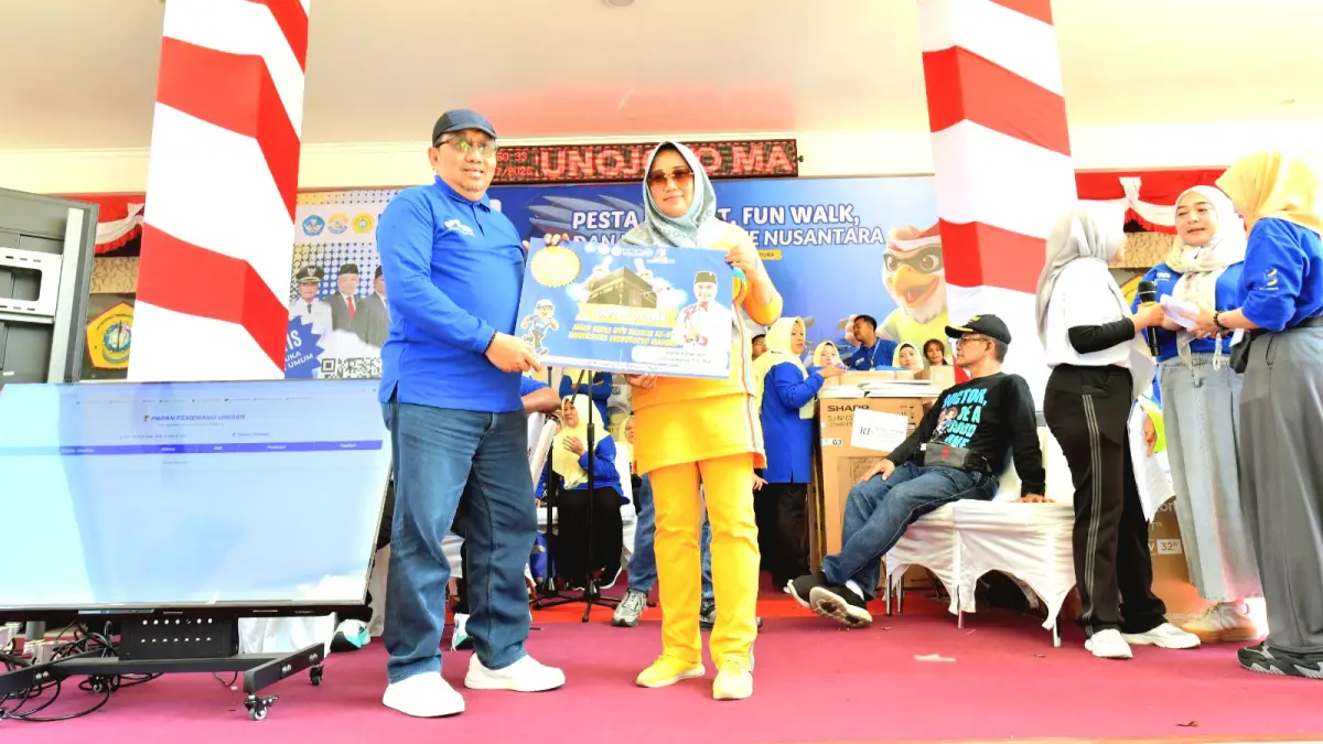 BAHAGIA: Mantan rektor UTM Prof. Dr. Drs. Ec. Muh. Syarif memberikan hadiah kepada peserta pemenang umrah gratis. (UTM UNTUK JPRM)