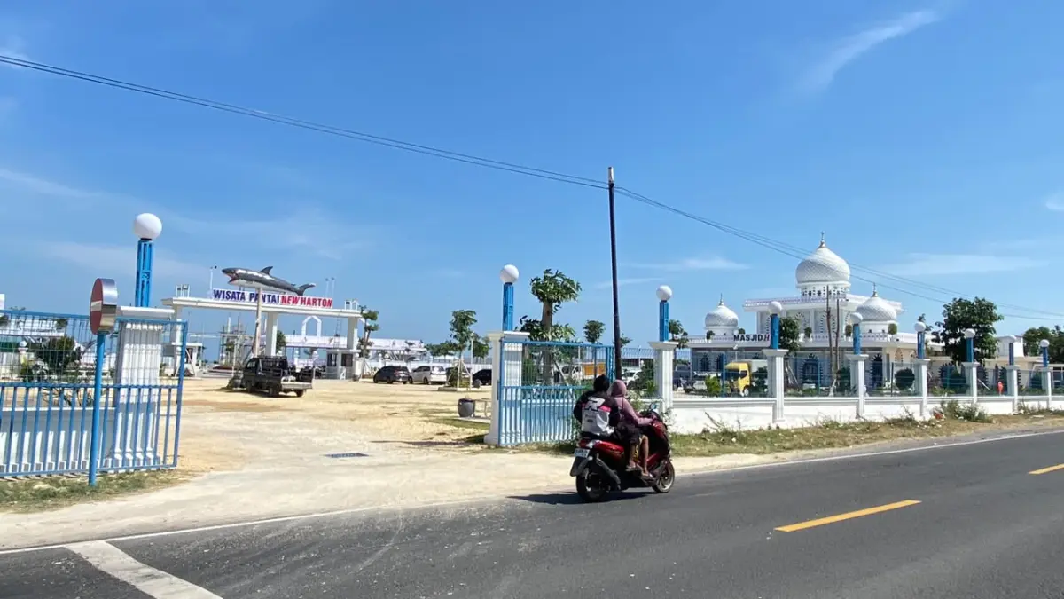 TEMPAT BERLIBUR: Pengendara motor melintas di depan Pantai New Harton, di Desa Tambahan, Kecamatan Camplong, Sampang, Kamis (23/7).