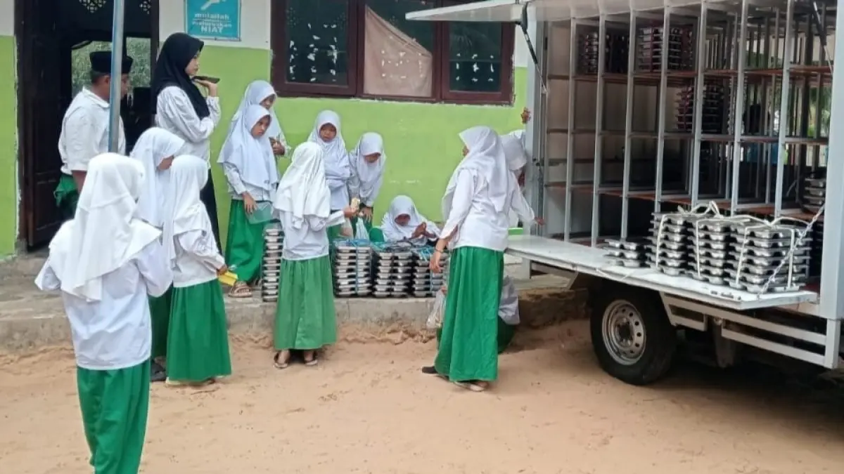 ANTUSIAS: Siswa MI Darul Ittihad Desa Lapa Taman menyambut kedatangan paket MBG yang didistribusikan SPPG Sumenep Dungkek Candi.