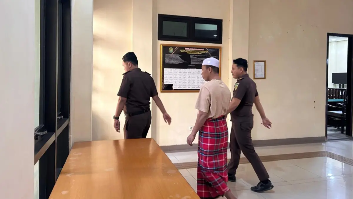DIKAWAL KETAT: Salah satu terdawa perkara tindak asusila anak di awah umur dikawal petugas tahanan kejaksaan di Sampang, Rabu (22/7).