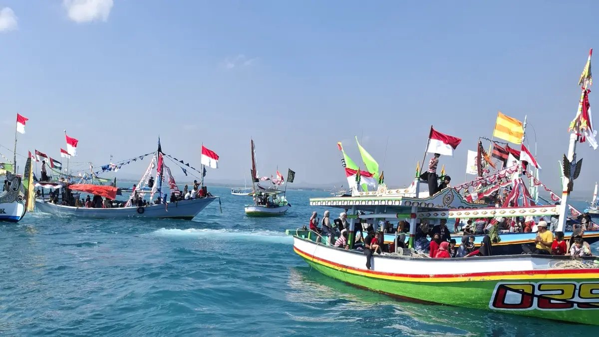 MERAWAT TRADISI: Nelayan bersama-sama melarung sesaji ke tengah laut saat perayaan rokat tase’ di Desa Banyusangka, Kecamatan Tanjungbumi, Bangkalan, Minggu (26/7).&nbsp;