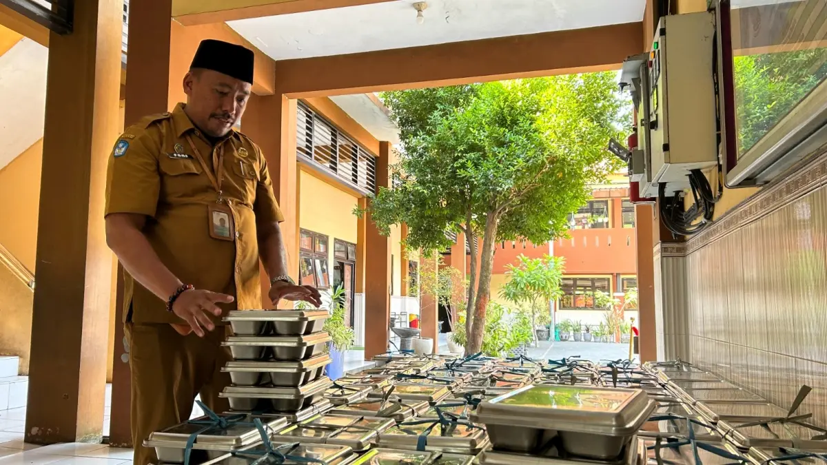 KETAT: Guru SDN Kemayoran 1 mengecek ompreng sebelum dikembalikan ke pihak dapur, Senin (13/7).