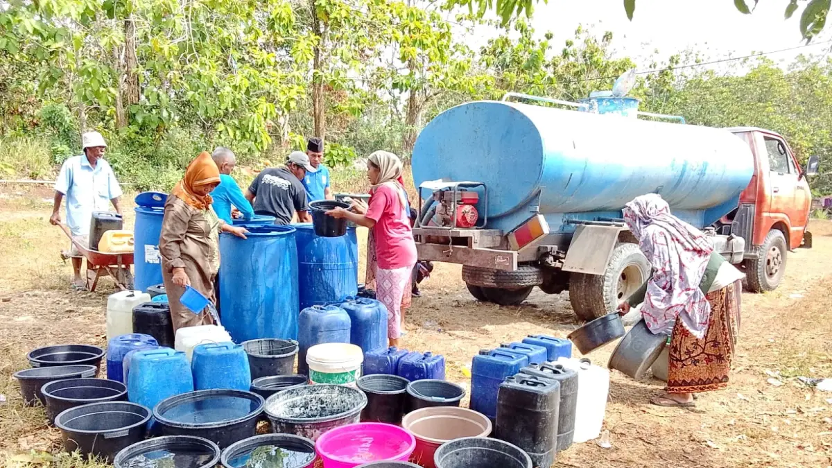 TERDAMPAK KEKERINGAN: Warga Desa Gunelep, Kecamatan Sepulu, antre untuk mendapatkan bantuan air bersih, Selasa (28/7).
