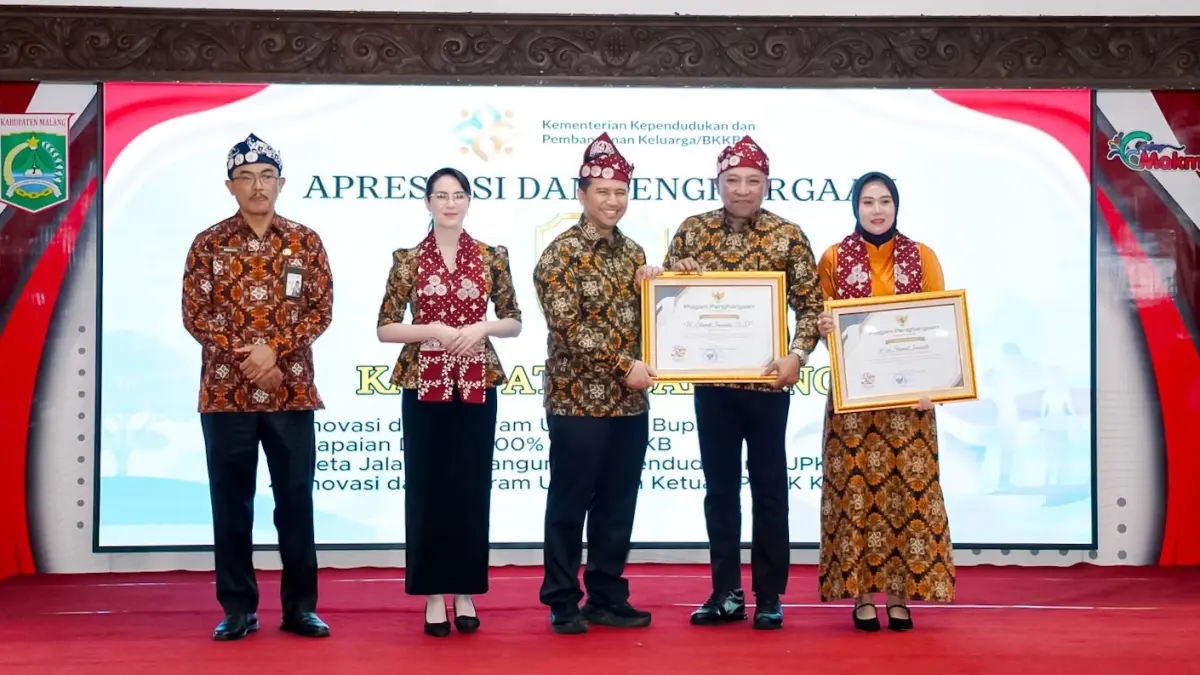 APRESIASI: Wagub Jatim Emil Elestianto Dardak menyerahkan piagam penghargaan kepada Bupati Sampang H. Slamet Junaidi bersama Ketua TP PKK Sampang Selviana Slamet Junaidi pada peringatan Harganas ke-33 Provinsi Jatim di Pendopo Agung Kabupaten Malang, Rabu (29/7). (PROKOPIM UNTUK JPRM)