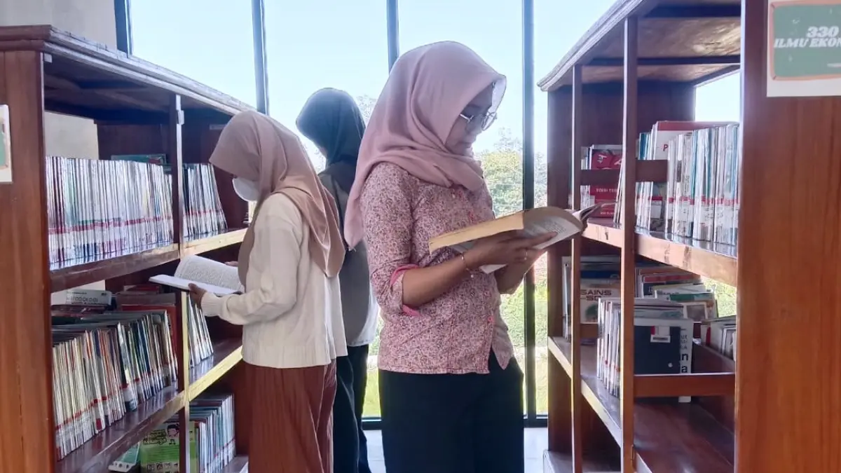 TINGKATKAN BUDAYA BACA: Tiga pelajar mencari referensi buku pelajaran biologi di Perpusda Bangkalan, Rabu (22/7). 