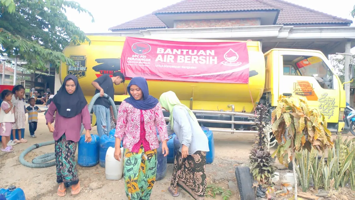 SENANG: Warga antusias untuk menerima bantuan air bersih yang didistribusikan DPC PDI Perjuangan Bangkalan, Sabtu (1/8). (DPC PDI PERJUANGAN BANGKALAN UNTUK JPRM)
