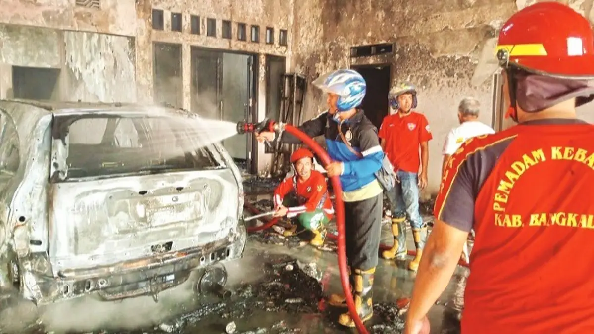 LUDES: Tim Damkar Bangkalan saat mengevakuasi kebakaran toko kelontong di Jalan RE Martadinata Bangkalan Sabtu (1/8). (DAMKAR BANGKALAN UNTUK JPRM)