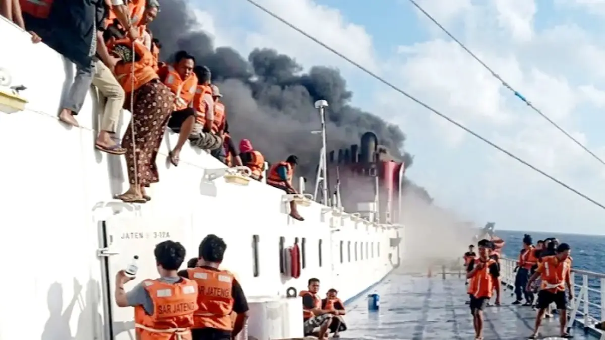 BUTUH PERTOLONGAN: Penumpang KM Mutiara Sentosa 2 memakai pelampung saat kapal yang ditumpangi terbakar di perairan utara Sumenep Minggu (2/8). (ISTIMEWA)