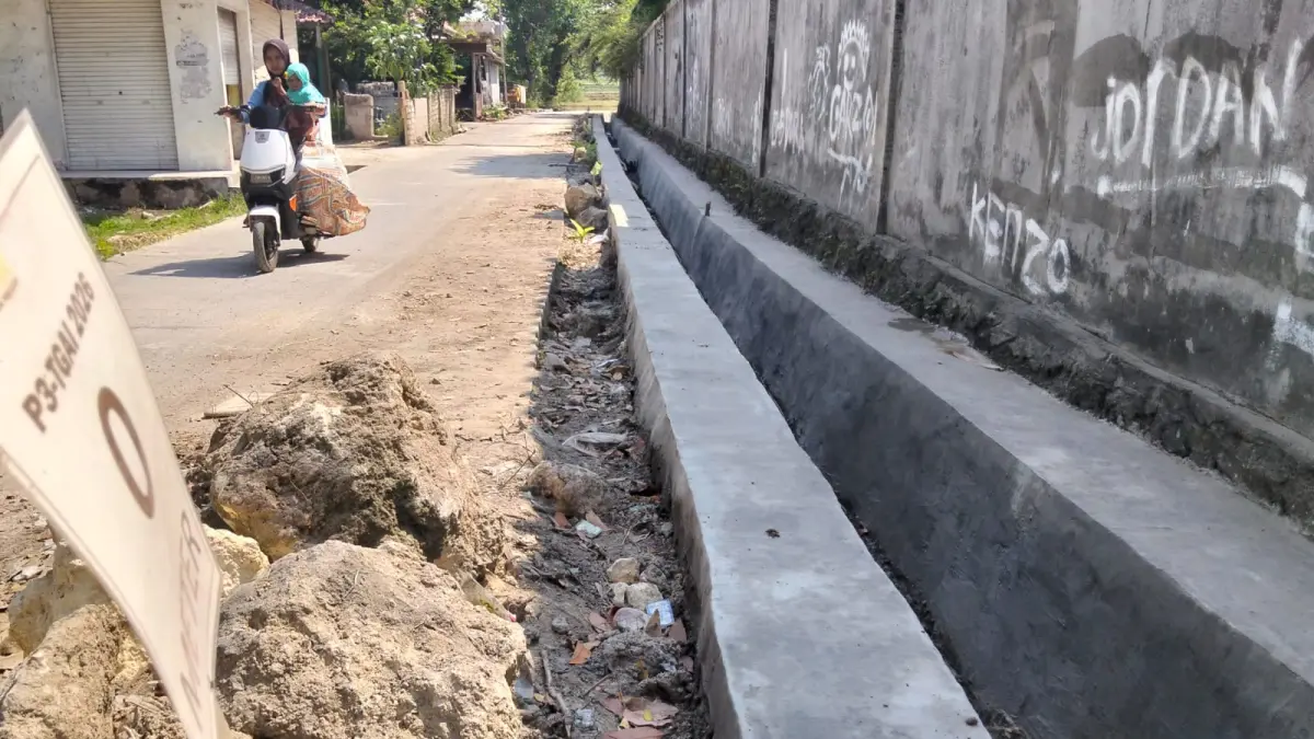 LENGANG: Warga melewati area pembangunan P3TGAI di Desa Taddan, Camplong, Sampang, Kamis (30/7). (ANIS BILLAH/JPRM)
