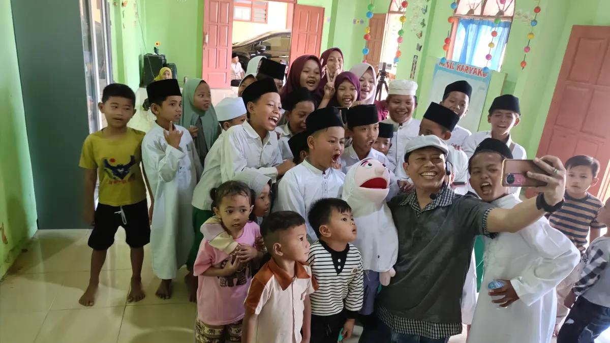 MENYENANGKAN: Kak Avan dan Kia foto bersama santri Yayasan Raudlatul Ulum Ar-Rahimy setelah mendongeng dalam rangka Kick Off Motivasi Belajar 2026, Minggu (2/8).
