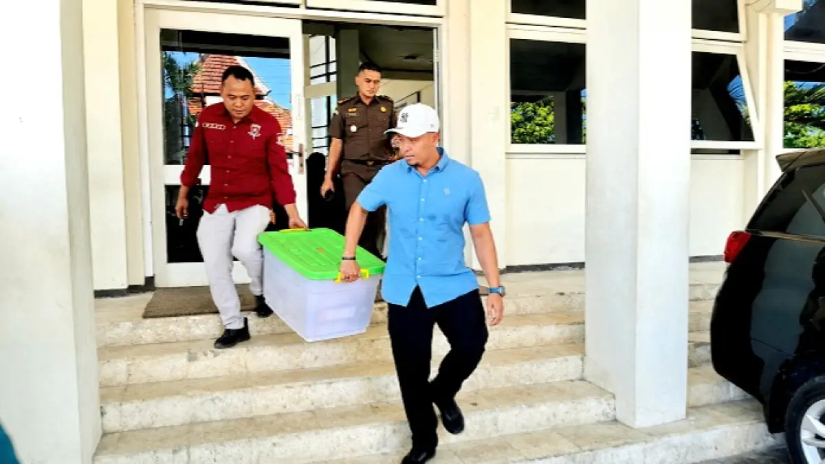 BARANG BUKTI: Penyidik Kejari Pamekasan keluar dari gedung Setkab Pamekasan dengan membawa satu boks berkas hasil penggeledahan, Rabu (5/8). (M. KHOLIL RAMLI/JPRM)
