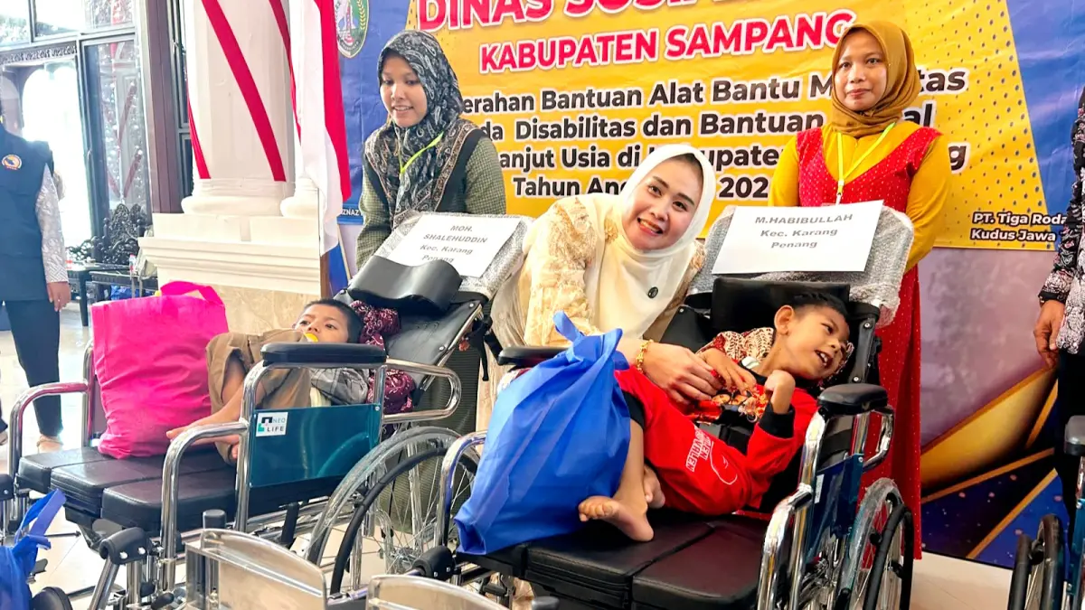 BERBAGI KEBAHAGIAAN: Ketua TP PKK Sampang Selviana Slamet Junaidi menyerahkan alat bantu mobilitas pada disabilitas di Peringgitan Pendopo Trunojoyo, Kabupaten Sampang, Kamis (6/8). (UBAIDILLAHIR RA’IE/JPRM)