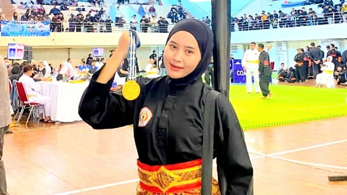 HARUMKAN NAMA KAMPUS: Anggita Dwi Cahyani memegang medali emas yang diraihnya dalam Kejuaraan Malang Championship V di GOR Ken Arok Malang pada Senin (27/7). (ANGGITA DWI CAHYANI UNTUK JPRM)