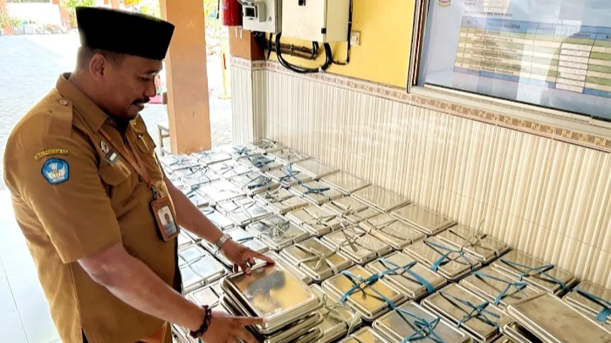 KETAT: Guru SDN Kemayoran 1 Bangkalan mengecek ompreng MBG sebelum dikembalikan ke pihak SPPG, Senin (13/7). (VIVIN AGUSTIN HARTONO/JPRM)