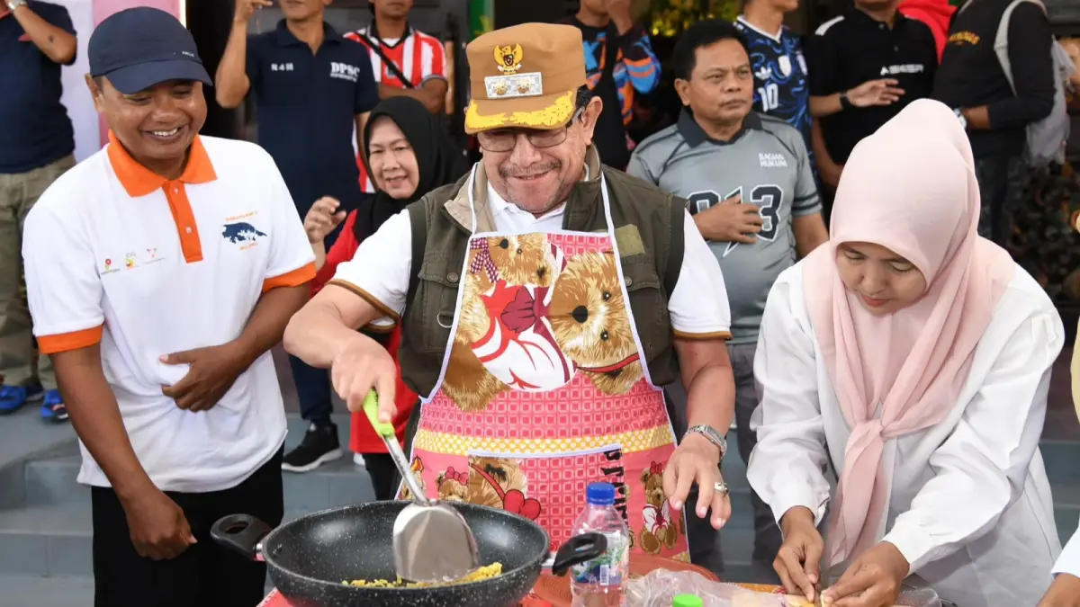 MEMBAUR: Wakil Bupati KH Imam Hasyim saat mengikuti lomba masak mi di halaman pemkab pada Rabu (5/8).