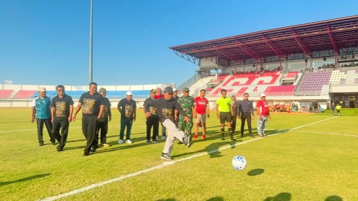 DIMULAI: Bupati Pamekasan KH Kholilurrahman menendang bola di SGMRP Pamekasan, Kamis (6/8). (MOH. IQBAL AFGANI/JPRM)