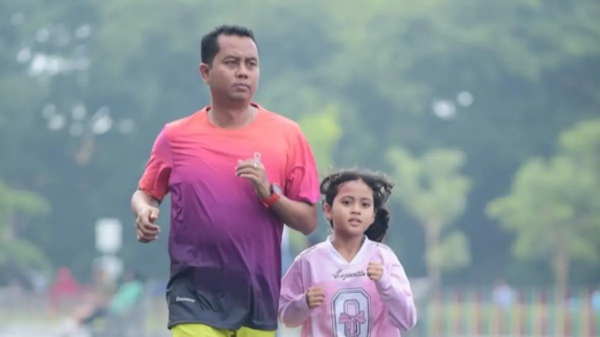 SEHAT: Kanit PPA Satreskrim Polres Sampang Ipda Poundra Kinan Aditama joging bersama buah hatinya di Jalan KH Wahid Hasyim, Alun-Alun Trunojoyo Sampang.