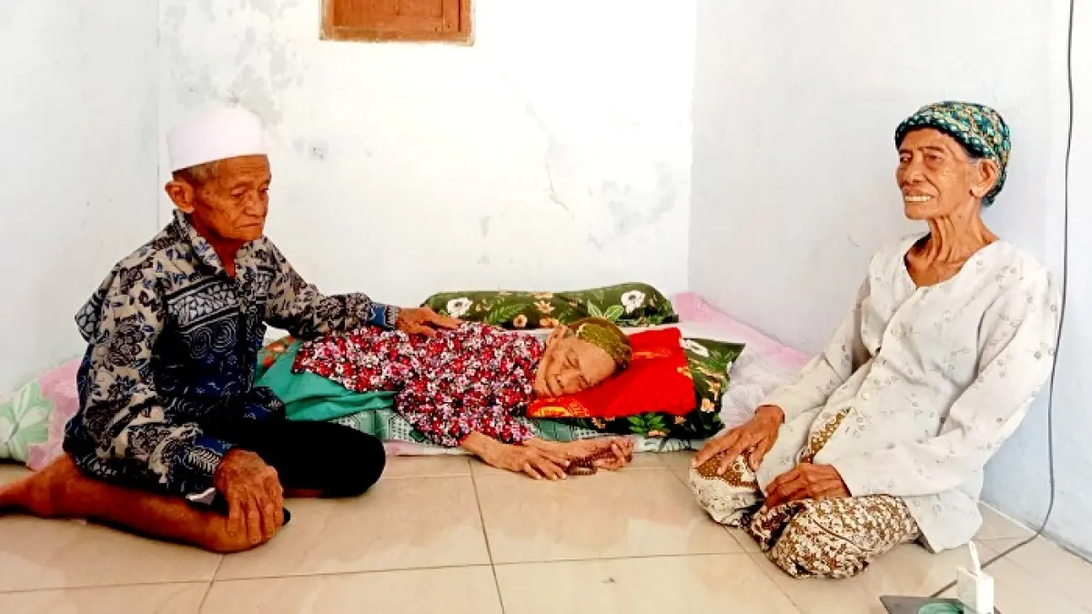 TERBARING: Nenek Siti Khotijah ditemani anaknya, Hafidah, dan menantunya, Osman, di rumahnya yang terletak di Dusun Jenglor, Desa Lajing, Kecamatan Arosbaya, Bangkalan, Jumat (7/8). (INA HERDIYANA/JPRM)