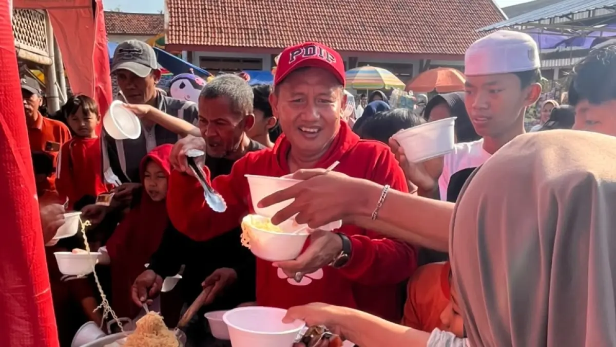 BERBAGI: Ketua DPC PDIP Sampang (pakai topi PDIP) saat berbagi mie instan bersama warga di Desa Pangelen, Sampang, Rabu (8/8).
