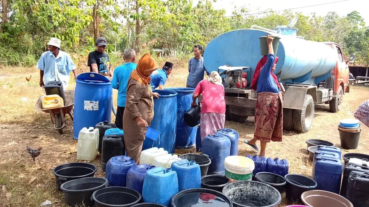 TERDAMPAK KEKERINGAN: Warga Desa Gunelep, Kecamatan Sepulu tampak antri air bersih Senin (27/7).