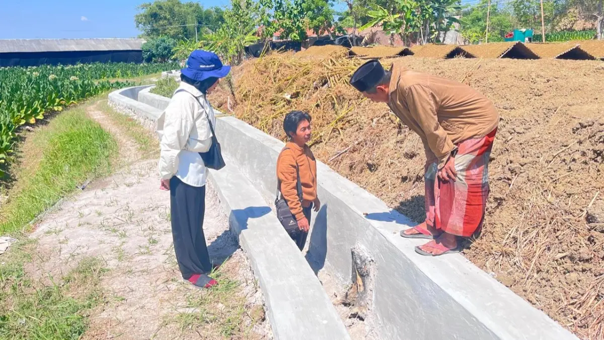 MINTA DIPERBAIKI: Asta P3TGAI Kecamatan Torjun Arif Rahman minta penanggung jawab pelaksanaan Hippa Ken Arok Markuat (pakai sarung) memperbaiki bangunan yang retak disaksikan TPM Faizatul Mukarromah, di Desa Pangongsean, Kecamatan Torjun, Sampang, Selasa (11/8). (ARIF RAHMAN UNTUK JPRM)