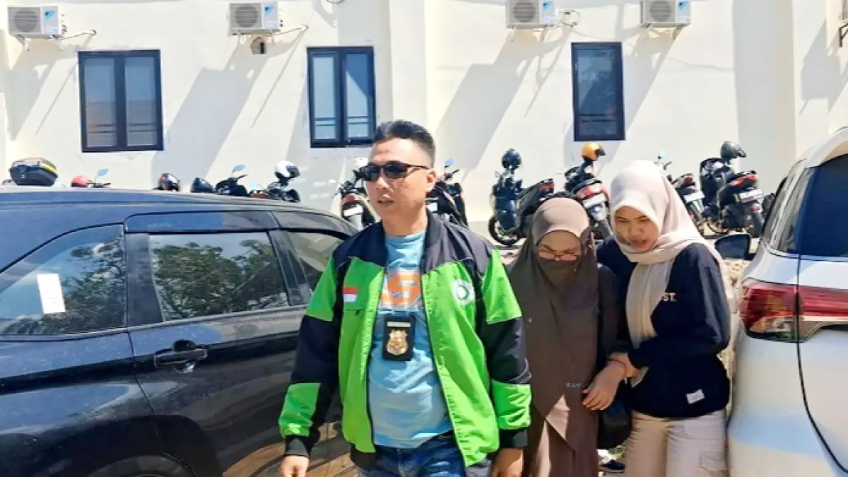 TERTUNDUK: Muaffah keluar dari mobil dikawal oleh penyidik Satreskrim Polres Pamekasan Selasa (11/8). (MOH. IQBAL AFGANI/JPRM)