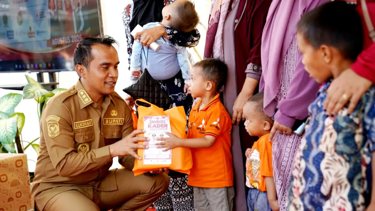 TINGKATKAN KESEHATAN ANAK: Bupati Bangkalan Lukman Hakim menyerahkan bantuan kepada balita di Puskesmas Konang Selasa (11/8). (PROKOPIM UNTUK JPRM)
