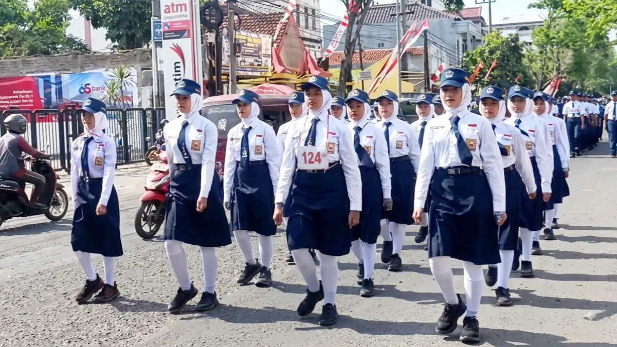 KOMPAK: Delegasi lomba gerak jalan UTPD SMPN 1 Bangkalan putri melewati rute di Jalan KH Moh. Toha, Sabtu (8/8). (SMPN 1 BANGKALAN UNTUK JPRM)